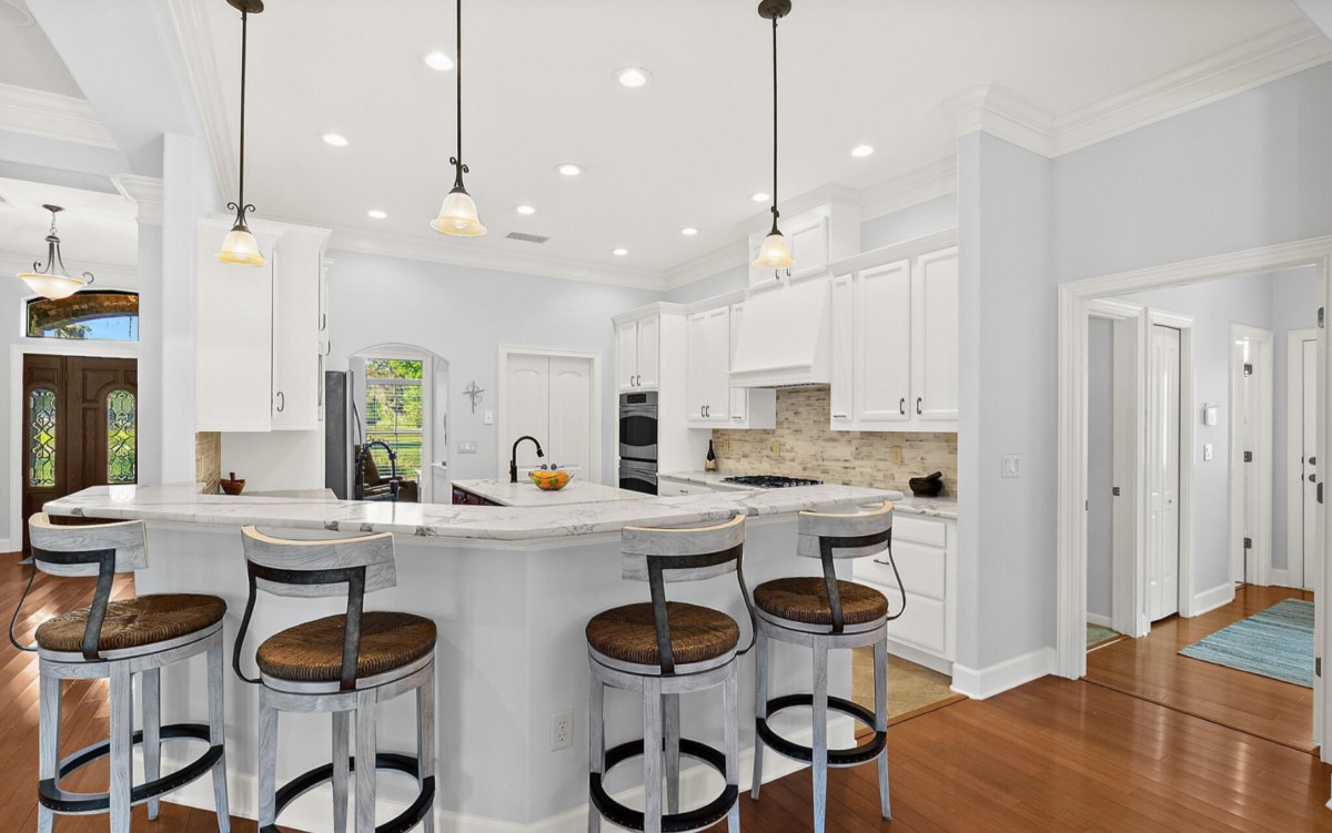 Kitchen with white painted cabinets, an island and a breakfast bar in Jacksonville, FL
