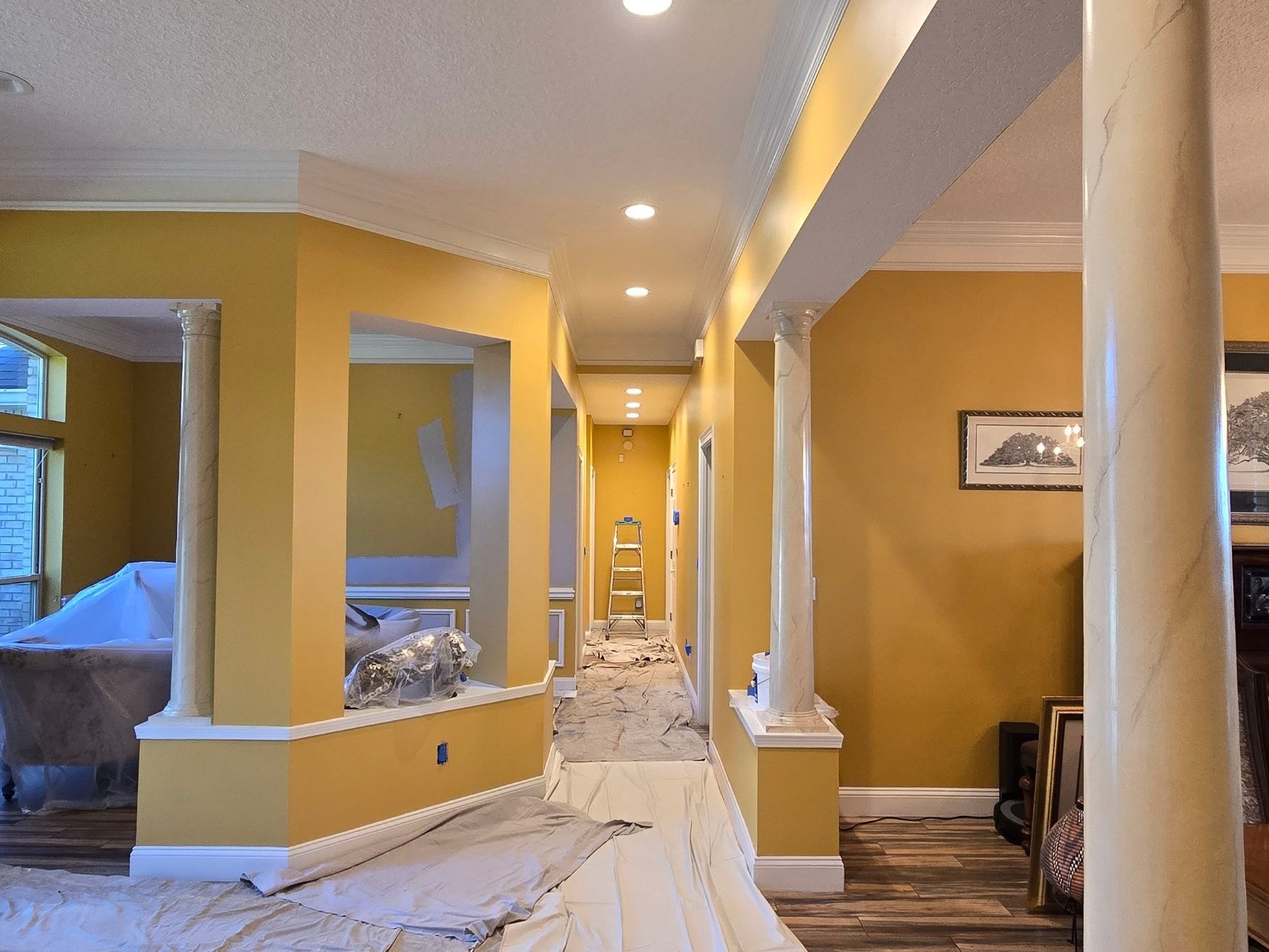 Queens Harbor entry and hallway before painting, gold walls and drop cloths down the hall