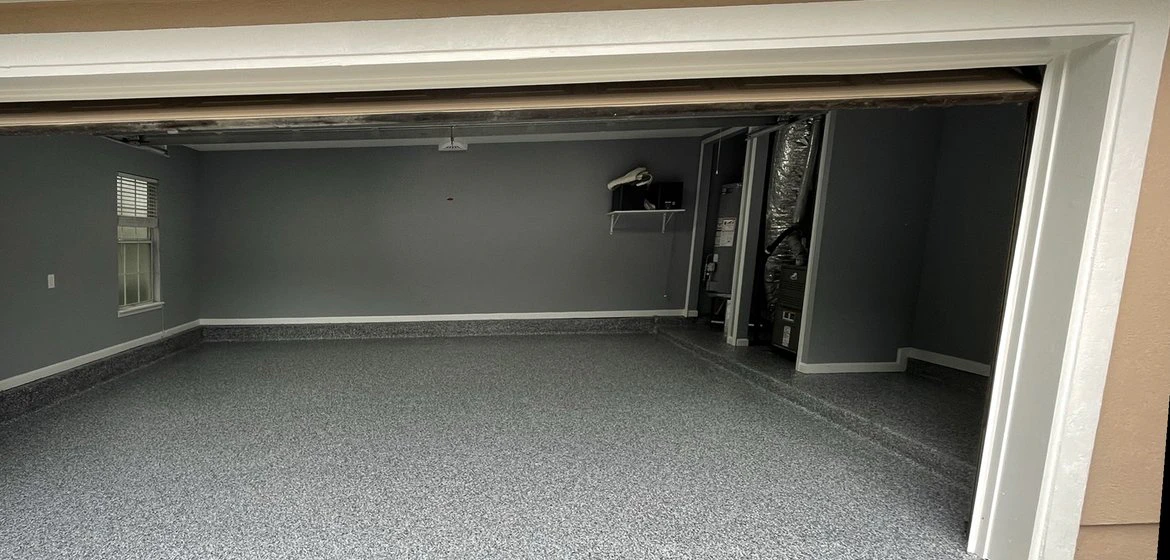 The same Palencia garage after diamond grinding and a grey flake polyaspartic coating, St. Augustine FL