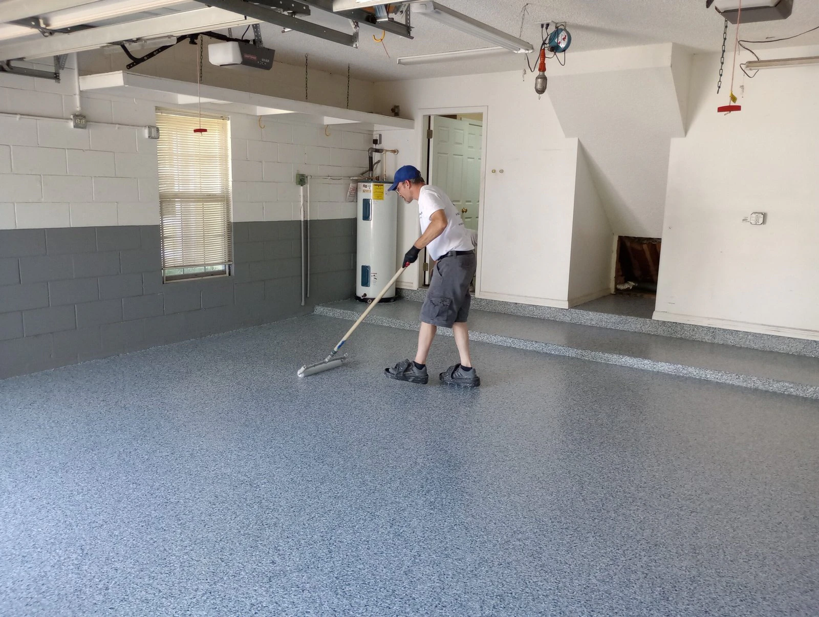 Painter rolling a garage floor coating