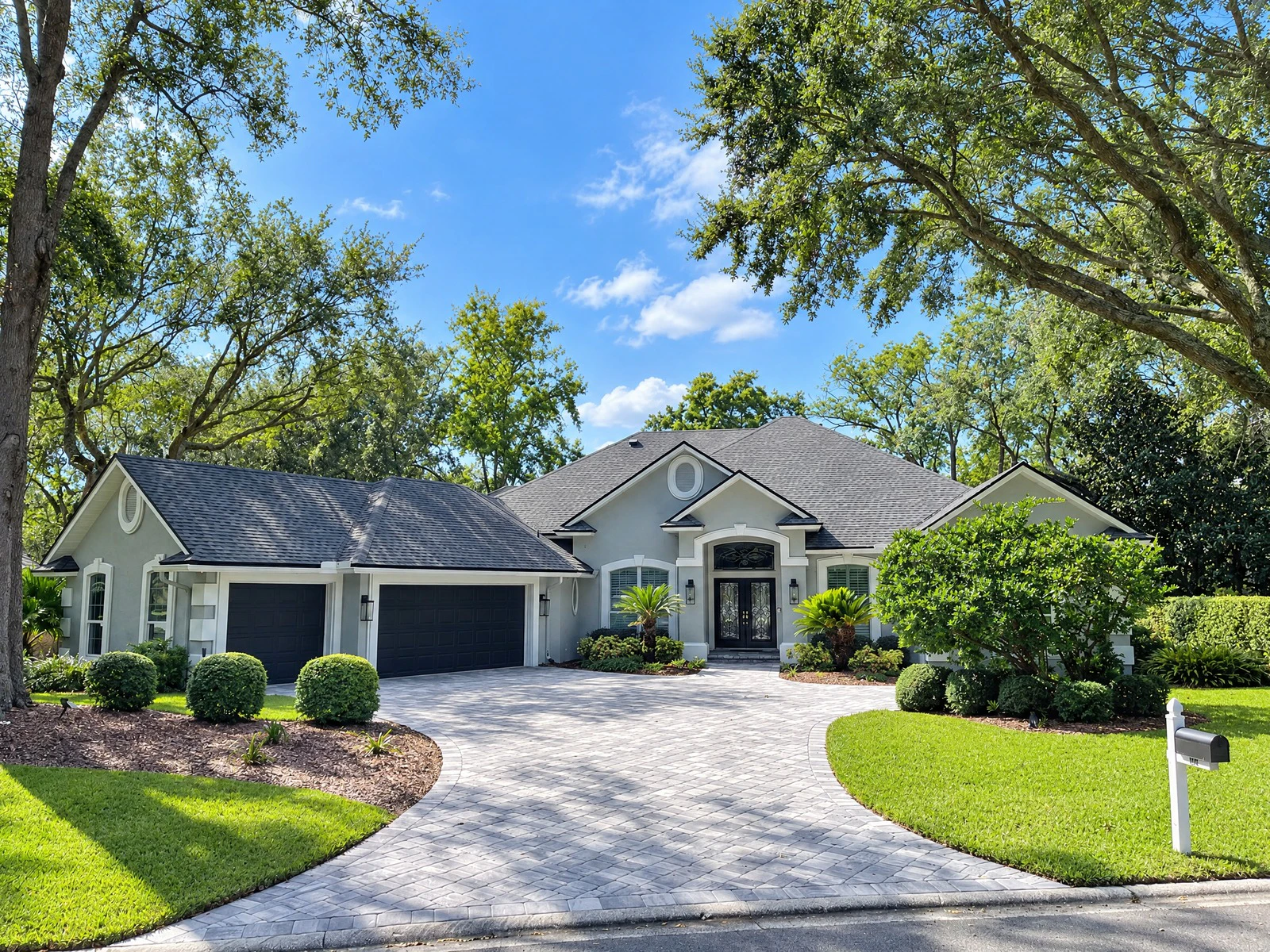Grey stucco exterior with black garage doors after repaint in Queen’s Harbour, Jacksonville FL