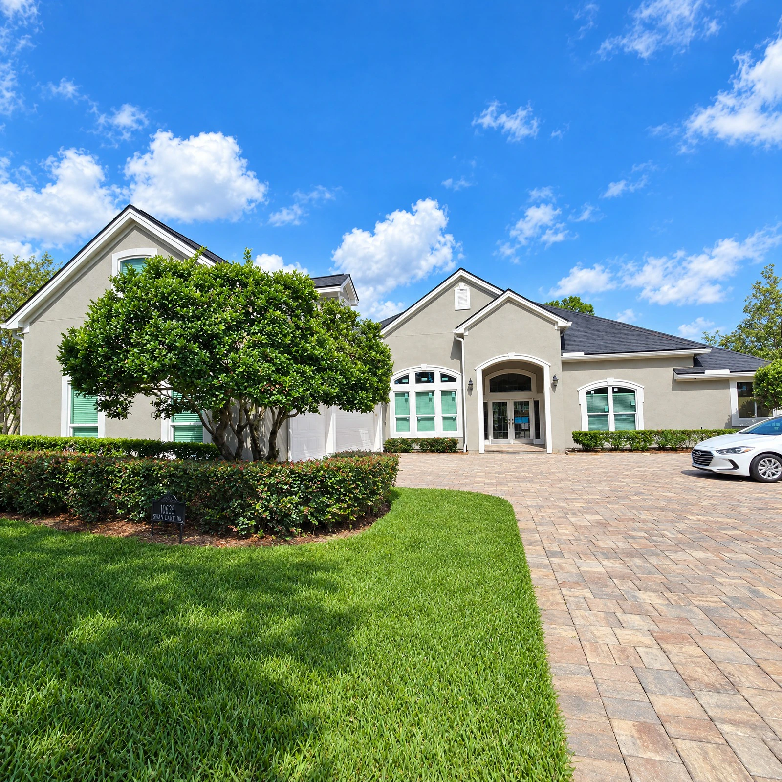 Freshly painted stucco home exterior with finished trim, fascia, soffits, and front entry in Deercreek, Jacksonville FL 32256