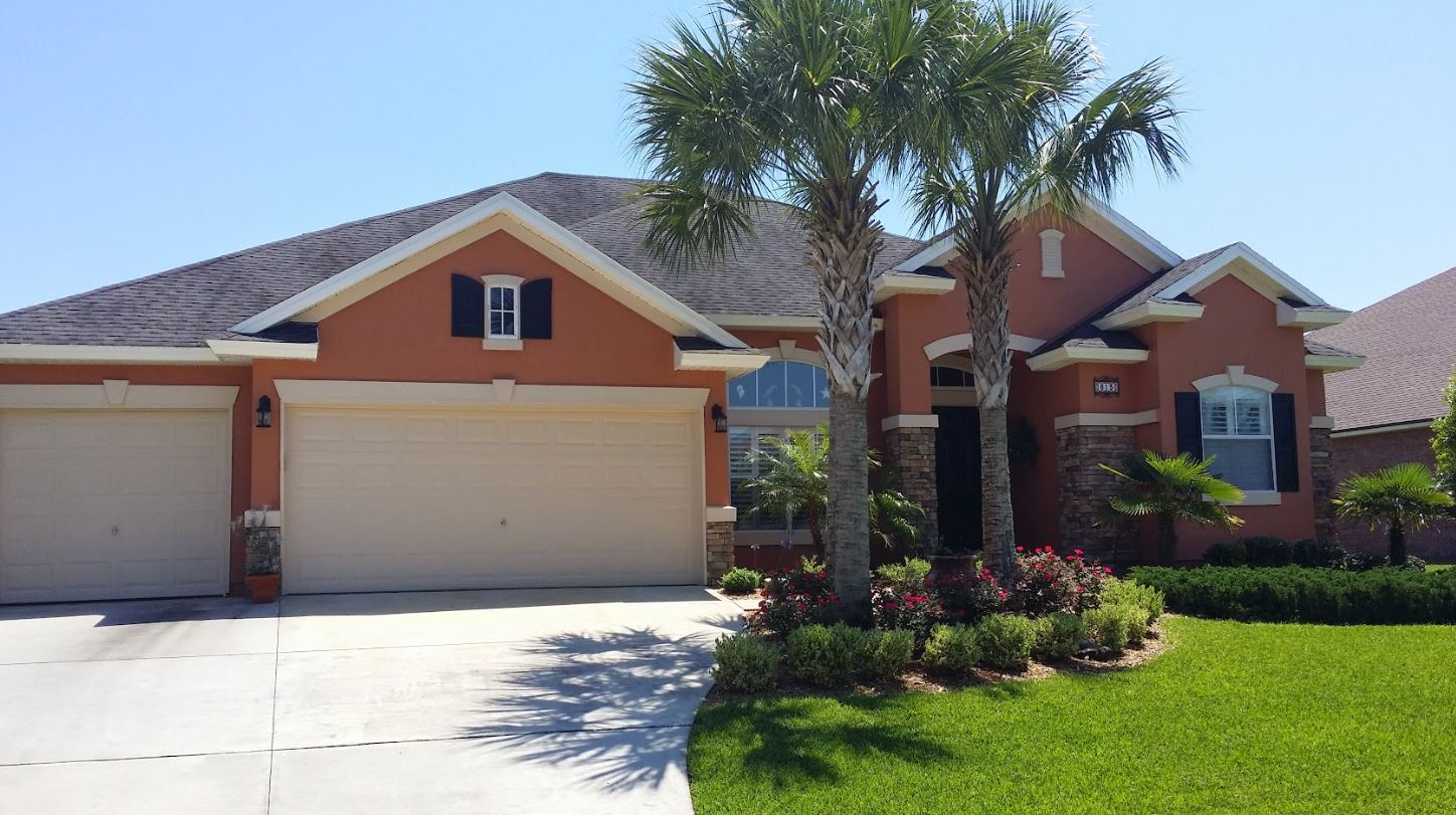 Exterior of a home showing repainted stucco and trim