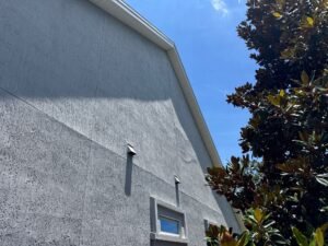 Crumbling, spalled stucco with loose material and exposed lath before professional repair