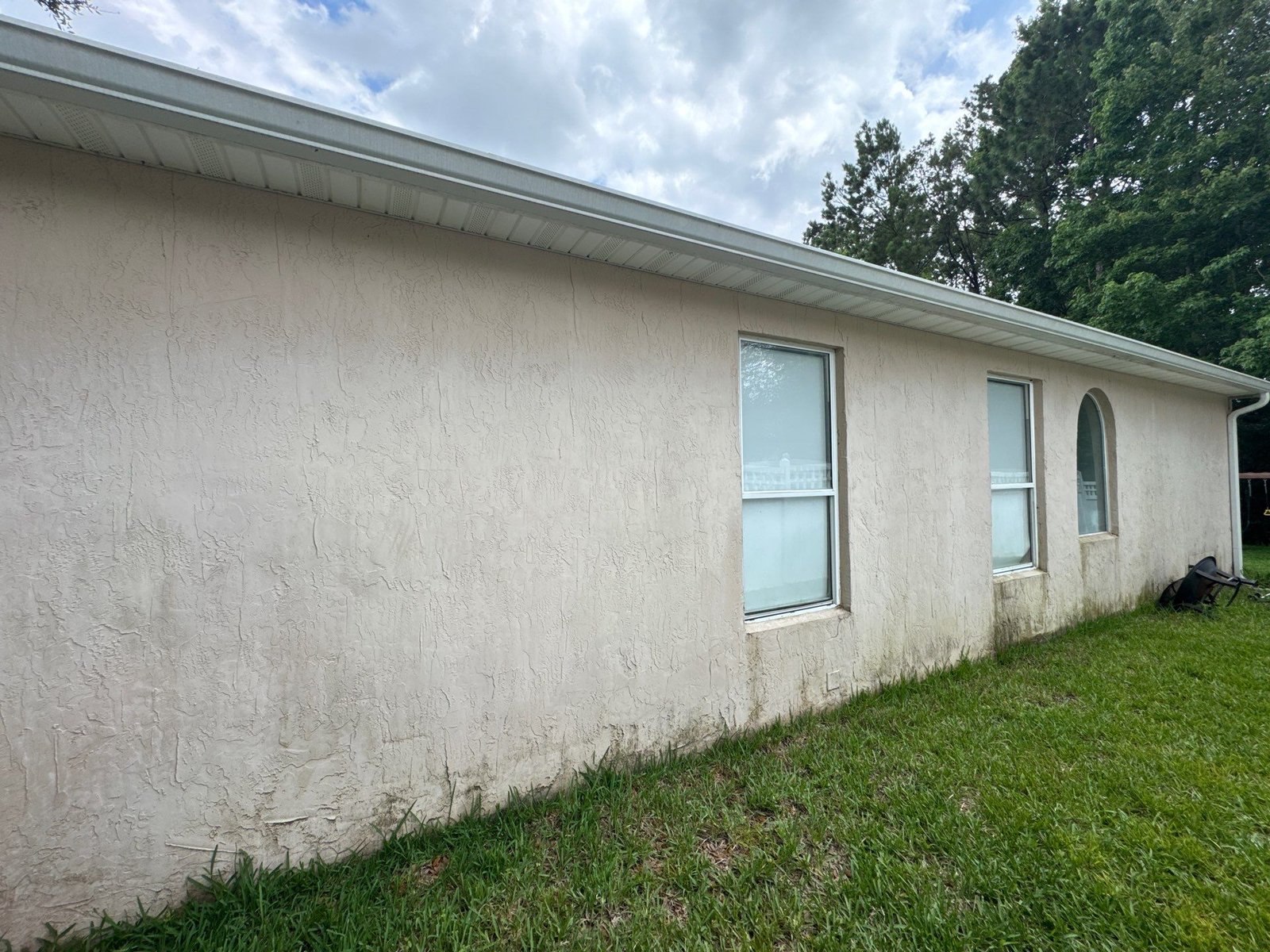 Close-up of chalky, powdery residue on exterior stucco paint on a Jacksonville, FL home
