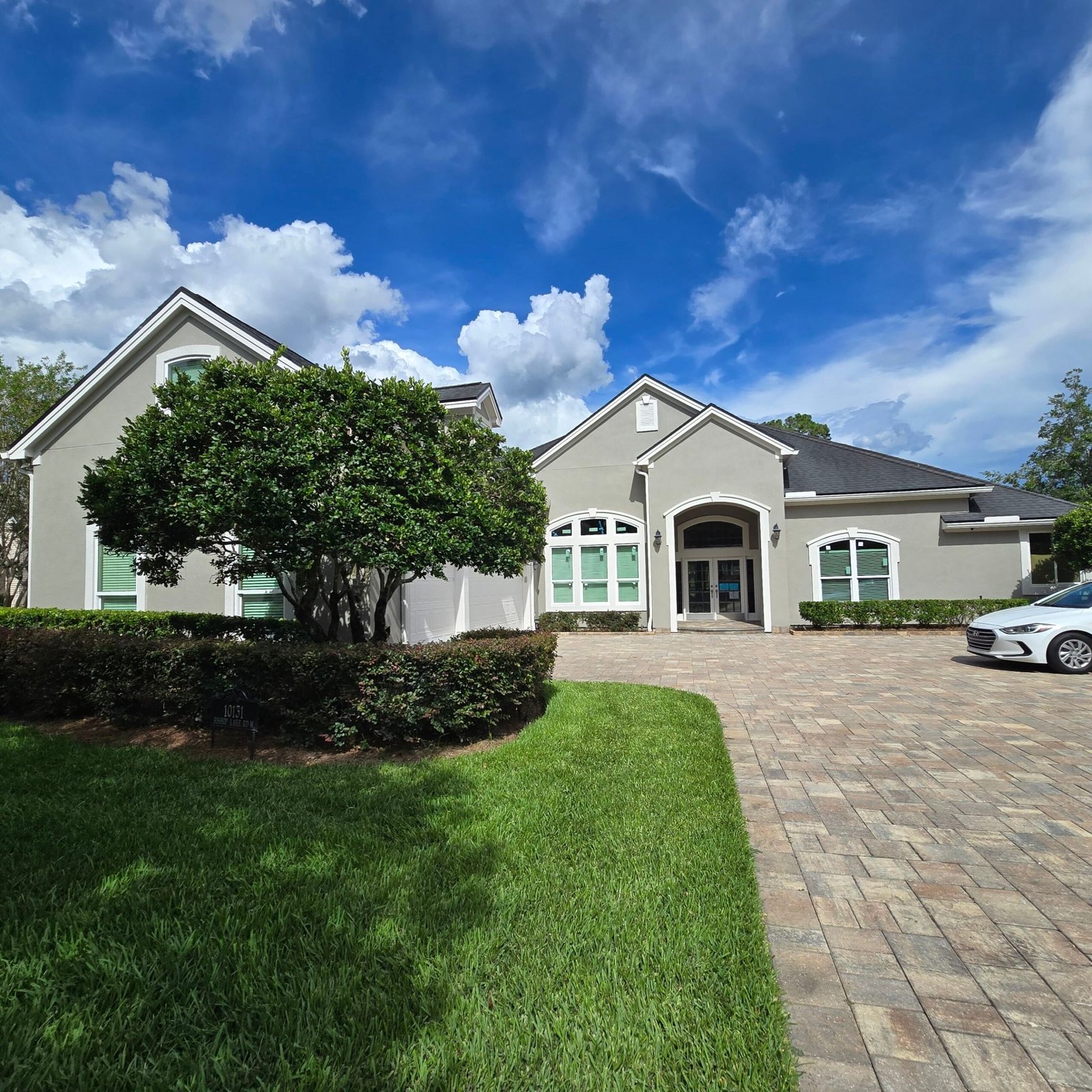 Freshly painted stucco home exterior with finished trim, fascia, soffits, and front entry in Deercreek, Jacksonville FL 32256