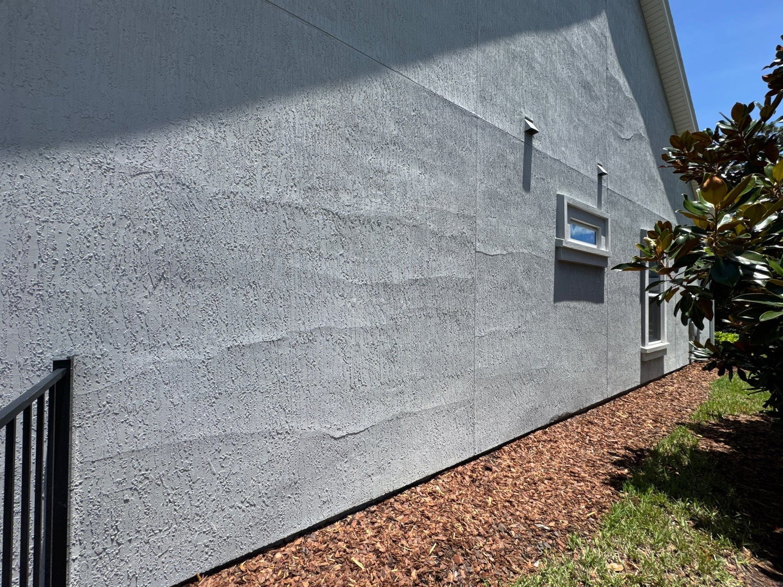 Stucco delamination showing sections separated and lifting away from the wall substrate