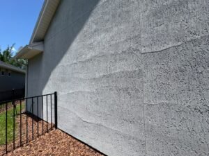 Stucco delamination showing sections separated and lifting away from the wall substrate