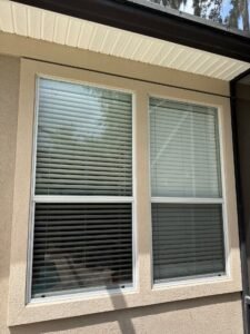 Close-up of stucco cracking around an exterior window before repairs