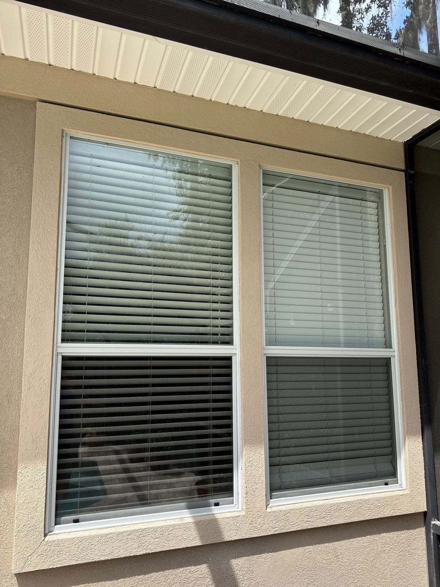 Close-up of stucco cracking around an exterior window before repairs