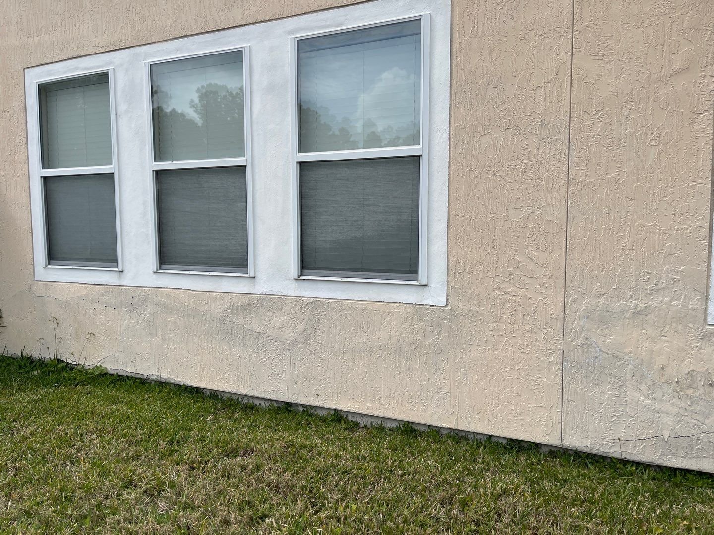 Loose stucco separating from the wall on a Jacksonville home