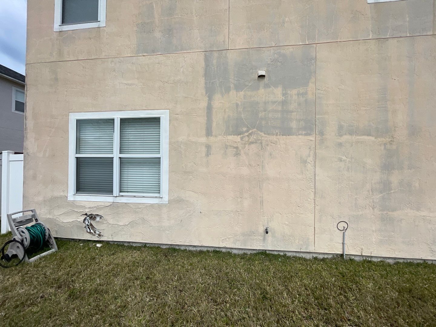 Stucco stain and delamination on Jacksonville home before exterior stucco repair