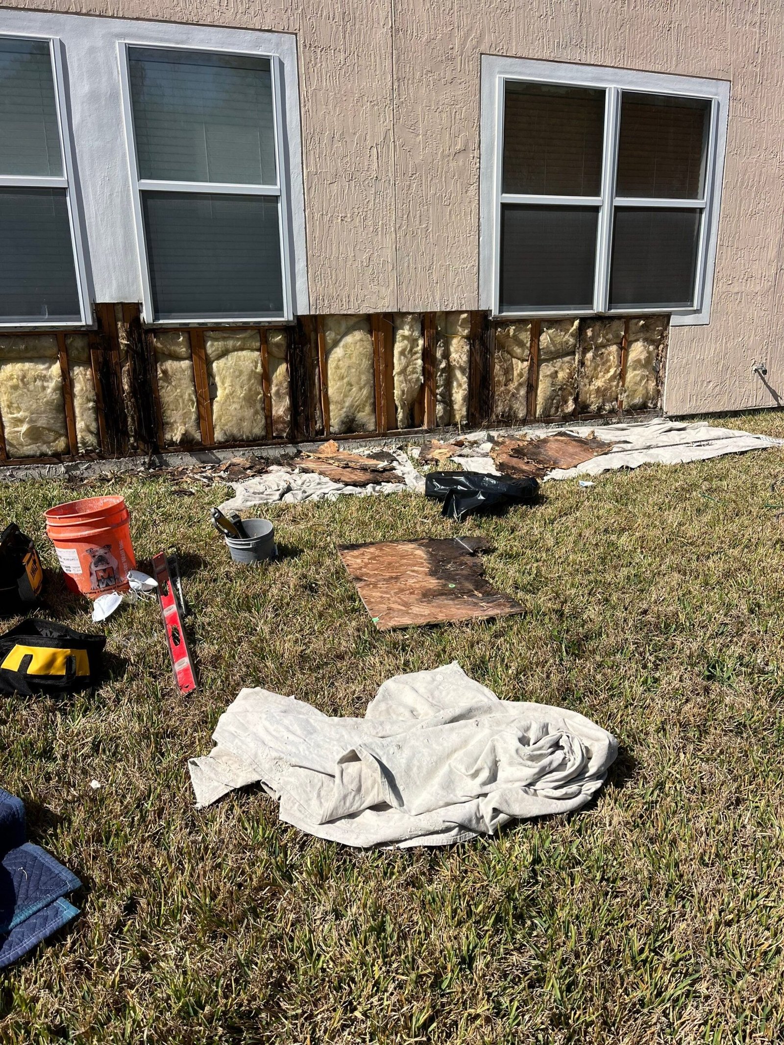 Deteriorated sheathing exposed behind a removed section of stucco
